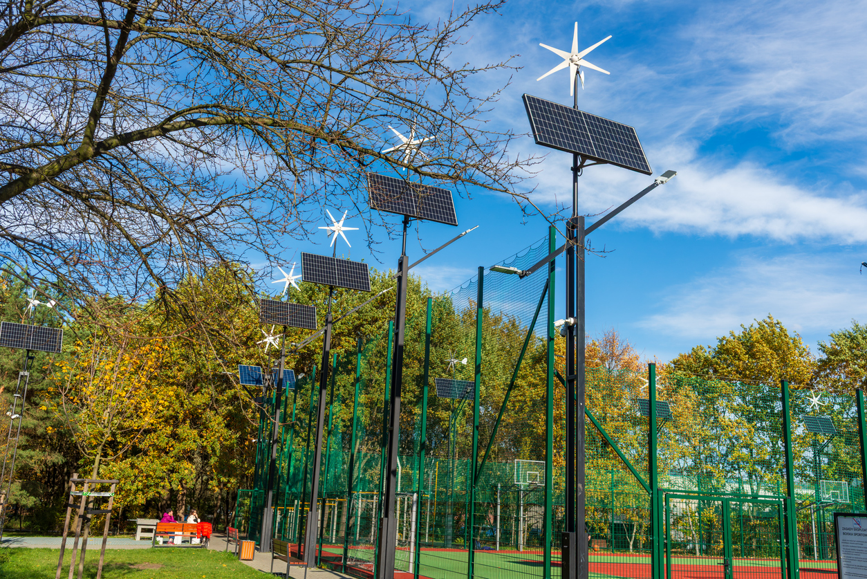 Mâts hybrides solaire et petit éolien éclairant un terrain de sport municipal