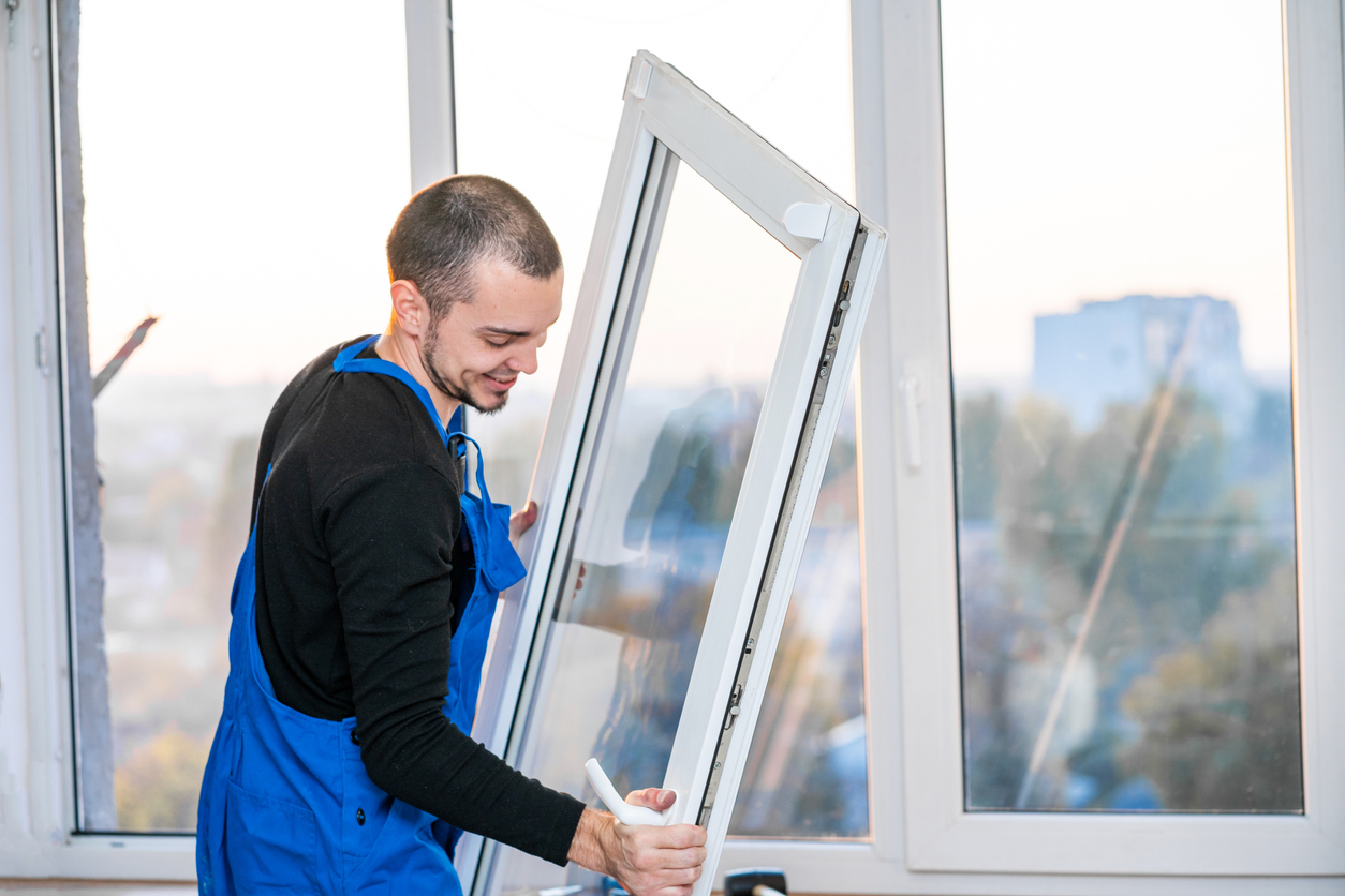 Poseur déposant un ouvrant de fenêtre existant en rénovation