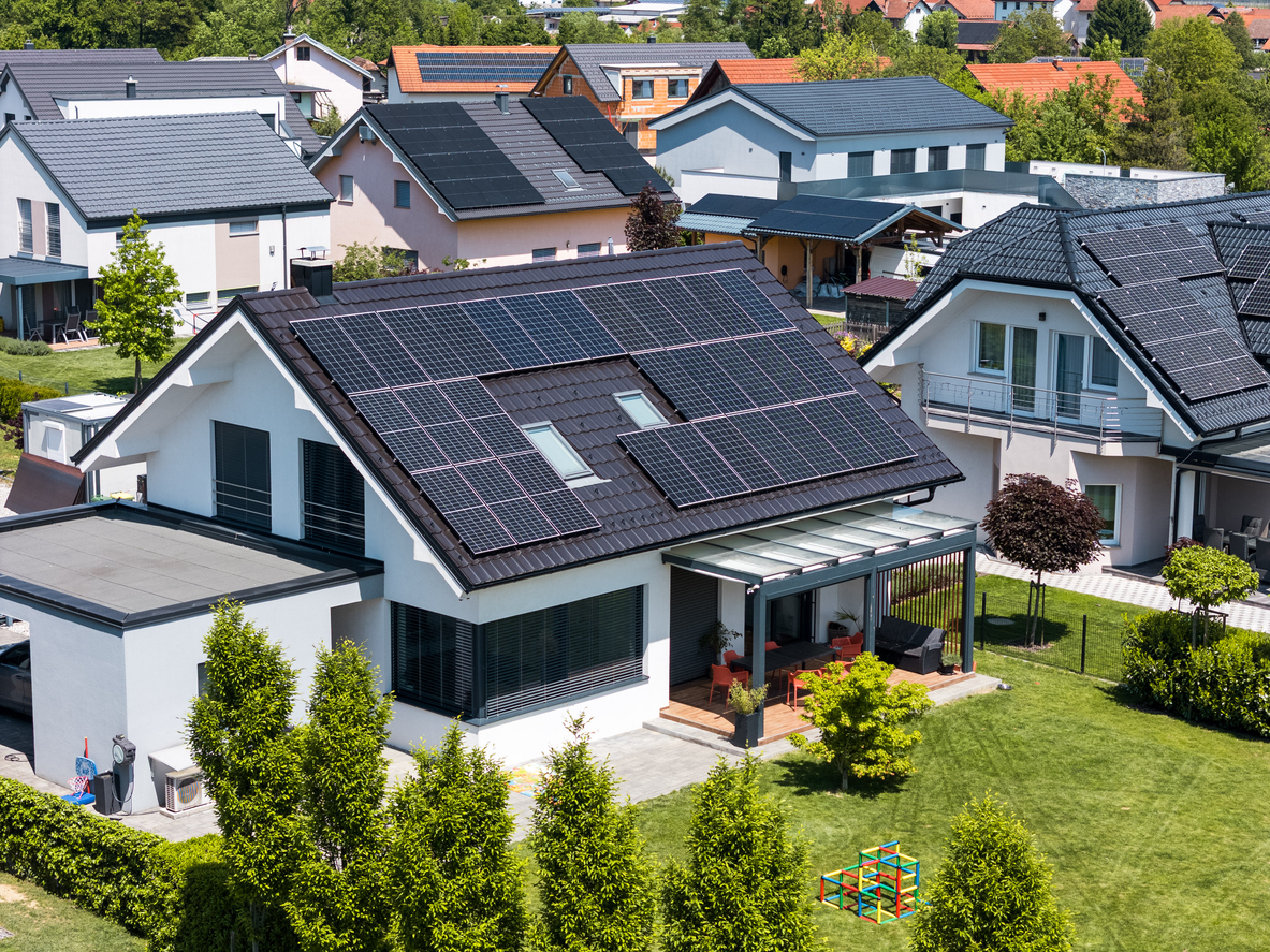 Maison d'habitation vue du ciel avec toiture noire intégralement couverte de modules photovoltaïques