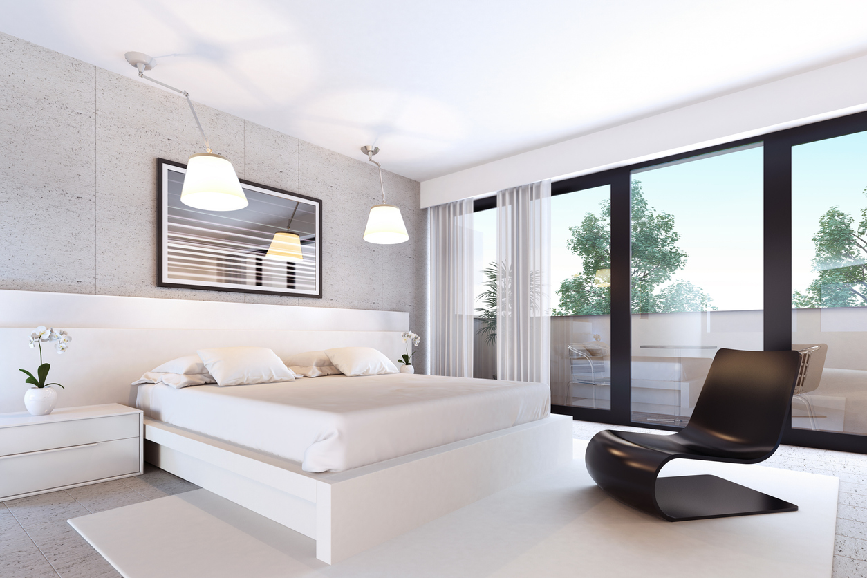 Chambre contemporaine avec baie vitrée coulissante à cadre noir ouvrant sur un balcon