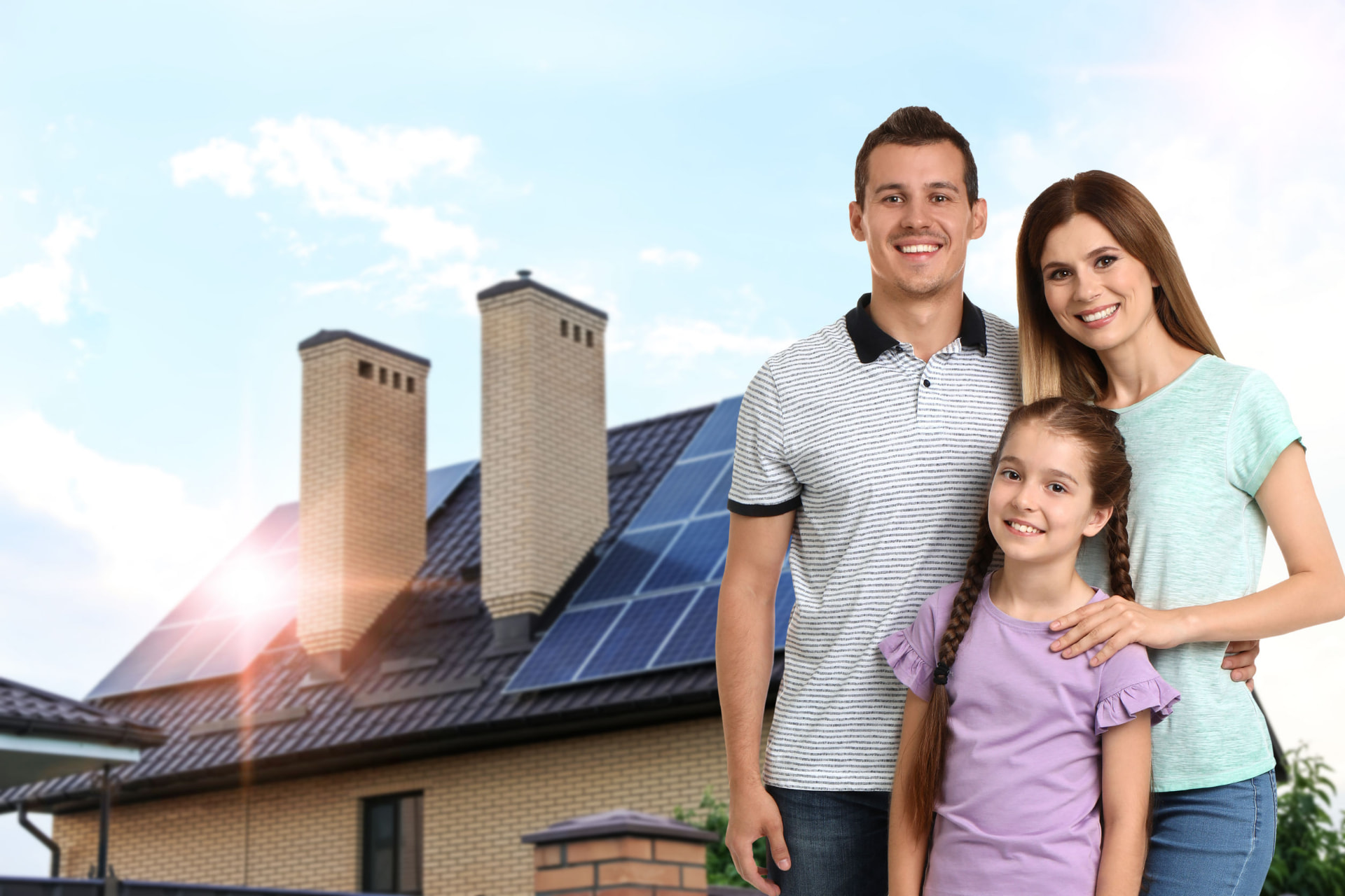 Famille devant sa maison équipée de panneaux photovoltaïques en toiture