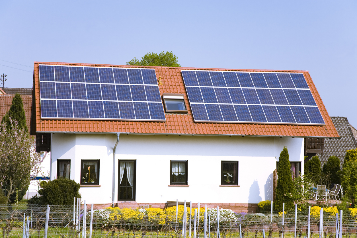 Deux champs de modules photovoltaïques en surimposition sur la toiture en tuiles d'une maison individuelle