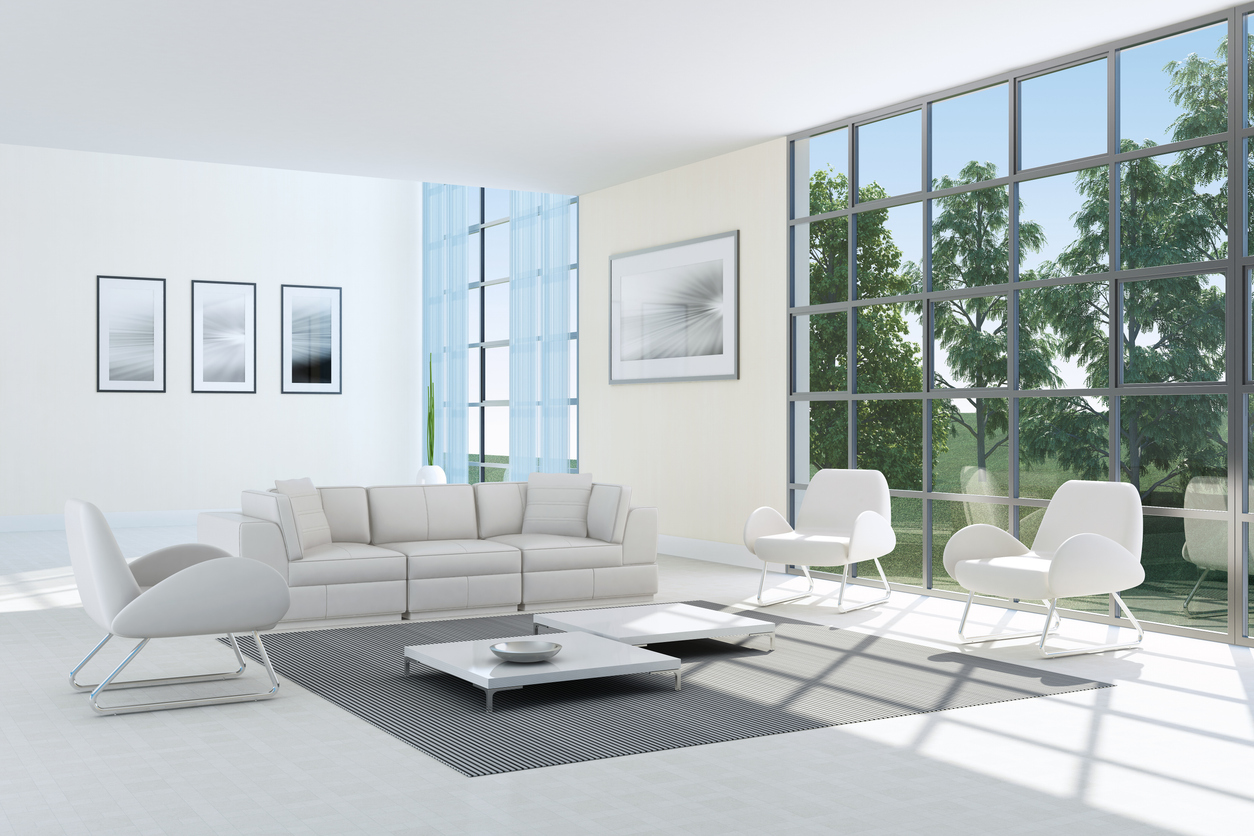 Séjour blanc contemporain ouvert sur un jardin par de grandes baies vitrées