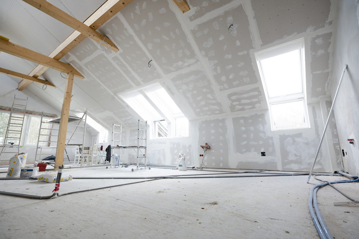 Combles aménagés en chantier : rampants isolés fermés par un parement de plaques jointoyées, fenêtres de toit posées