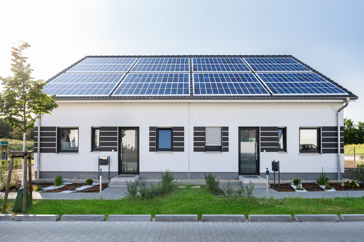 Bâtiment mitoyen à toiture unique couverte de quatre champs de modules photovoltaïques