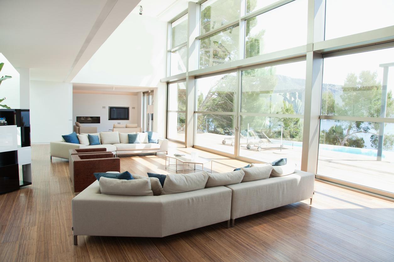 Pièce de vie avec parquet et baies vitrées toute hauteur après isolation intérieure
