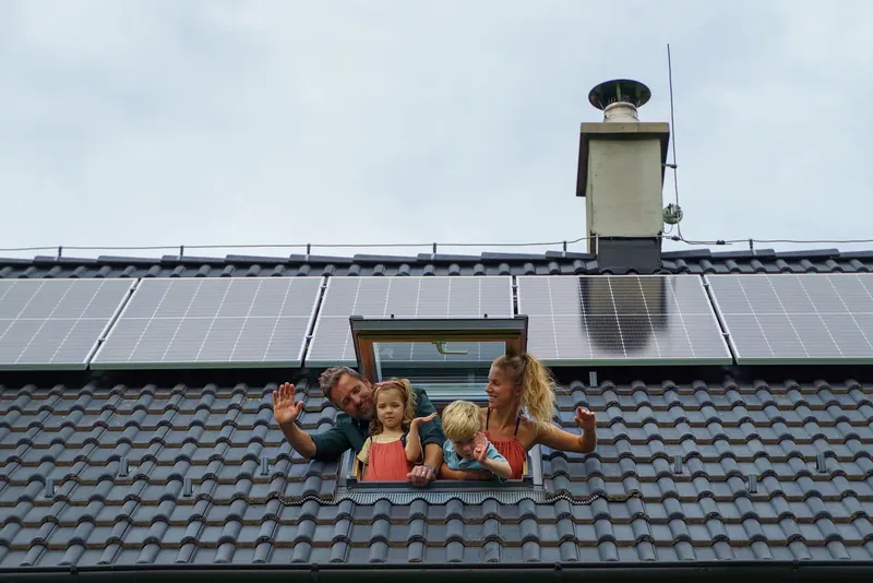 Famille à la fenêtre de toiture d'une maison — en Bourgogne-Franche-Comté