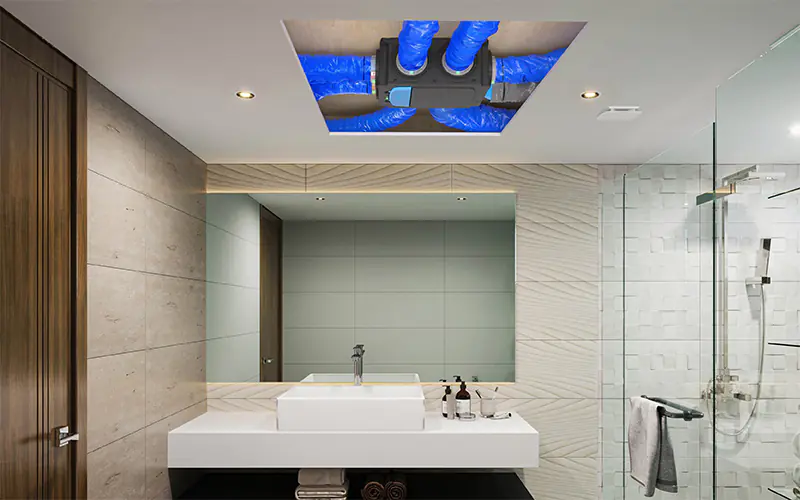 Caisson de VMC simple flux et conduits isolés visibles au plafond d'une salle de bain