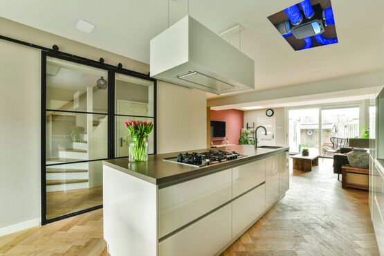 Caisson de VMC simple flux hygroréglable installé en faux plafond au-dessus d'une cuisine