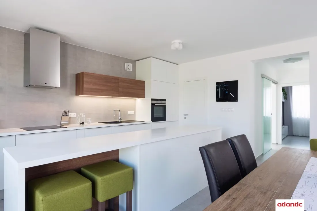 Cuisine ouverte d'un logement équipée d'un aérateur individuel mural et d'un détecteur au plafond