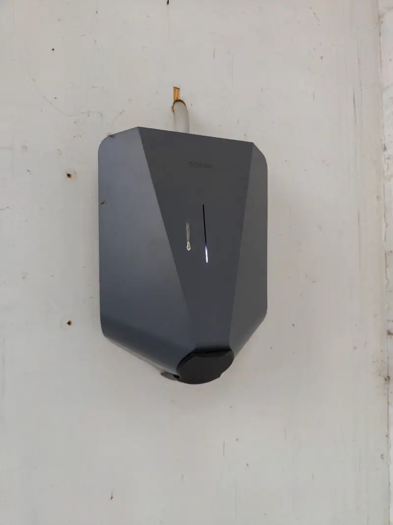 Borne de recharge murale installée sur la façade d'une maison