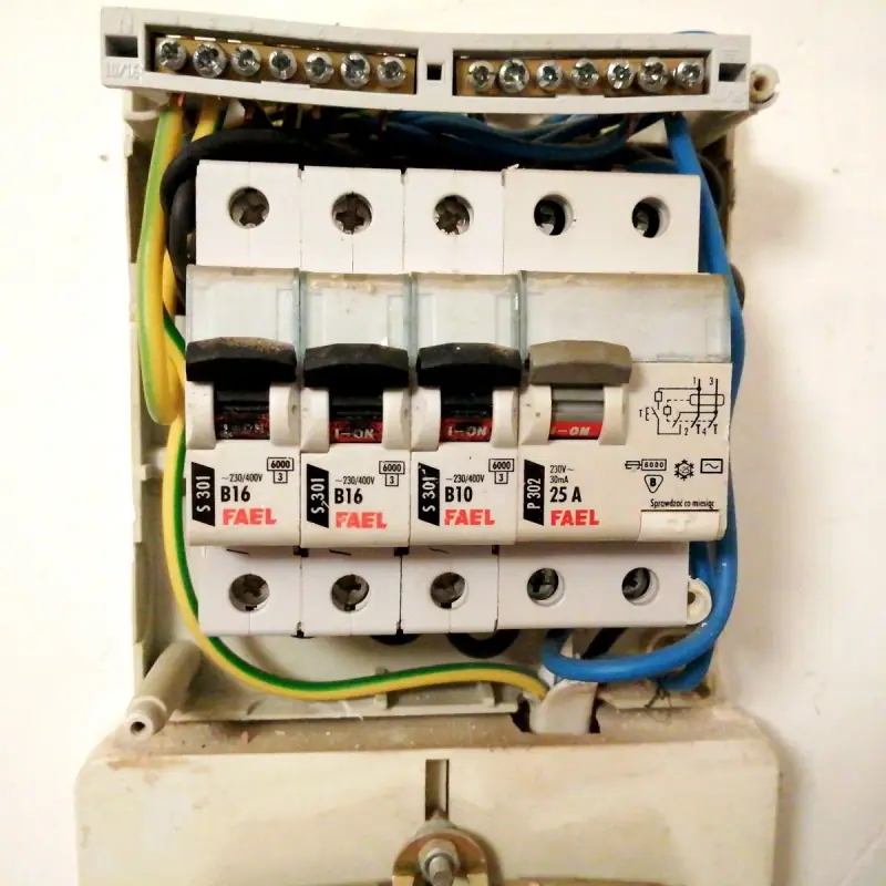 Électricien contrôlant un tableau électrique existant