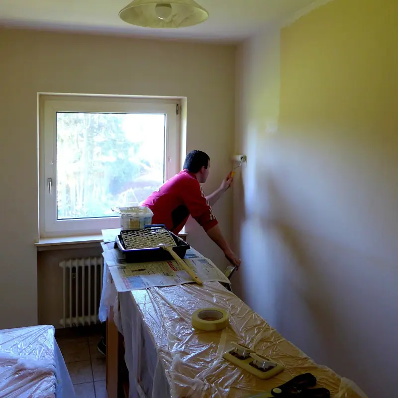 Application de peinture au rouleau sur un mur intérieur de logement