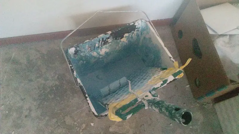 Bac et rouleau de peinture sur un chantier de rénovation d'appartement