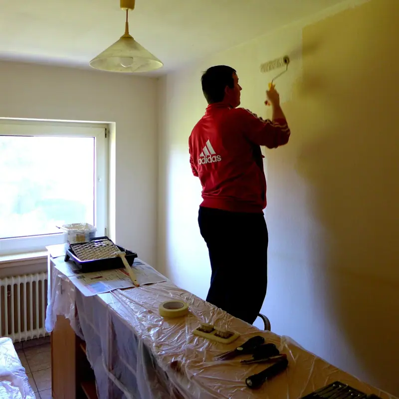 Préparation d'un mur intérieur avant mise en peinture, sols protégés