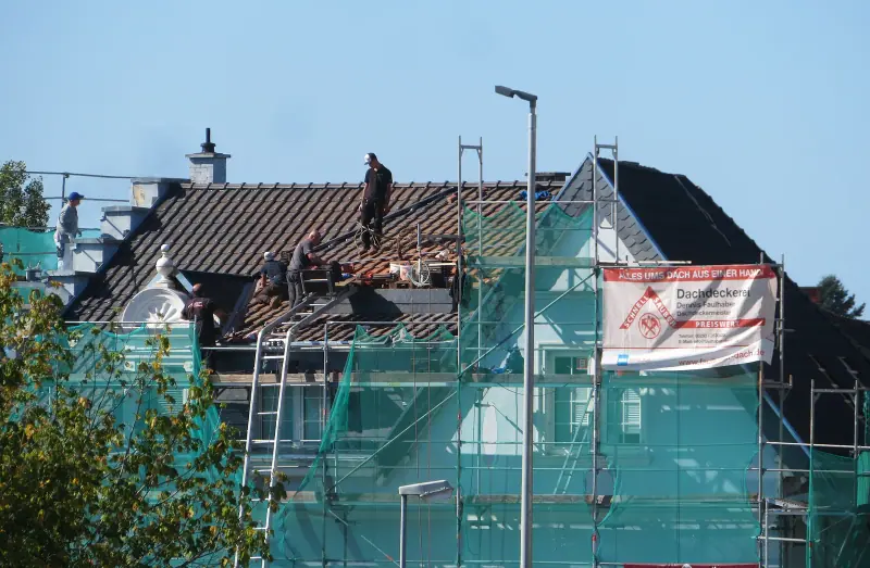 Couvreur au travail sur une toiture en cours de réfection