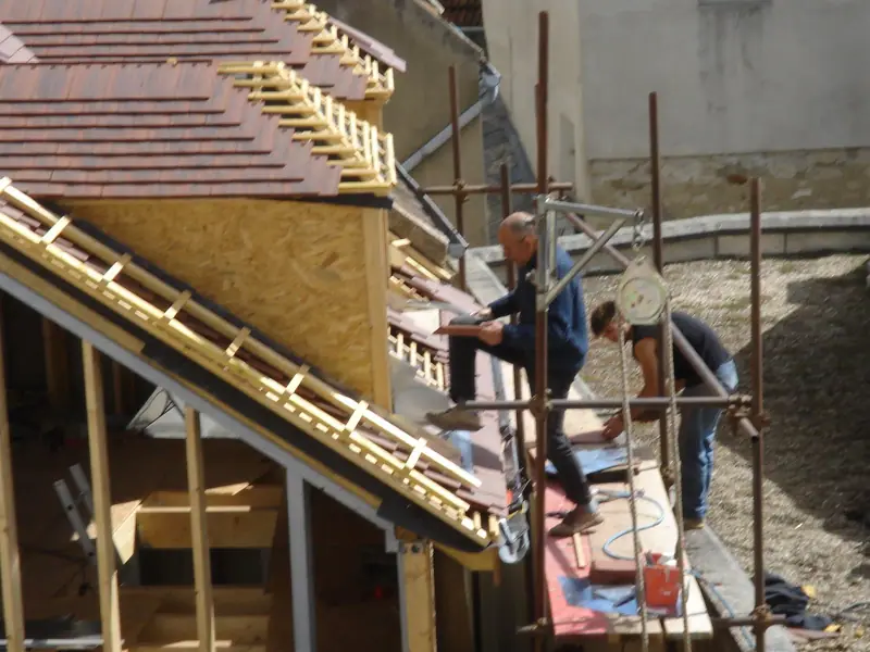 Couvreurs travaillant sur une toiture en ardoise