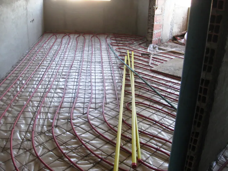Tubes de plancher chauffant déroulés avant coulage de la chape