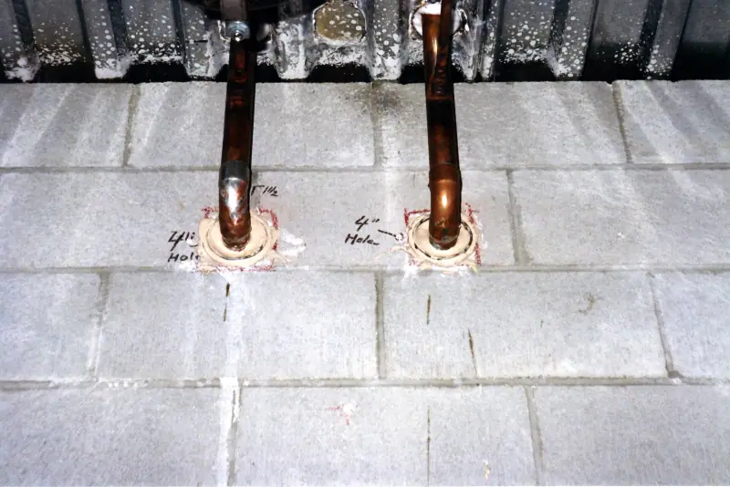 Tubes de cuivre traversant une paroi avec dispositif de calfeutrement