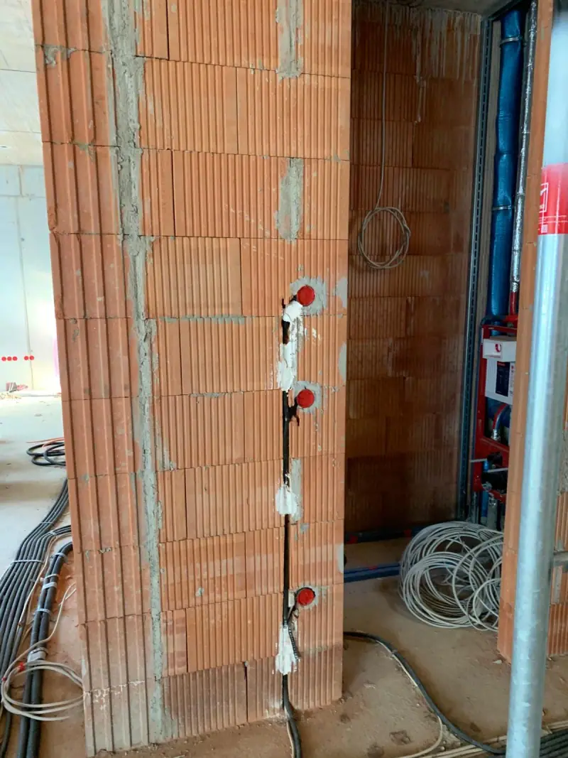 Câblage électrique déployé dans une cloison avant fermeture des parements